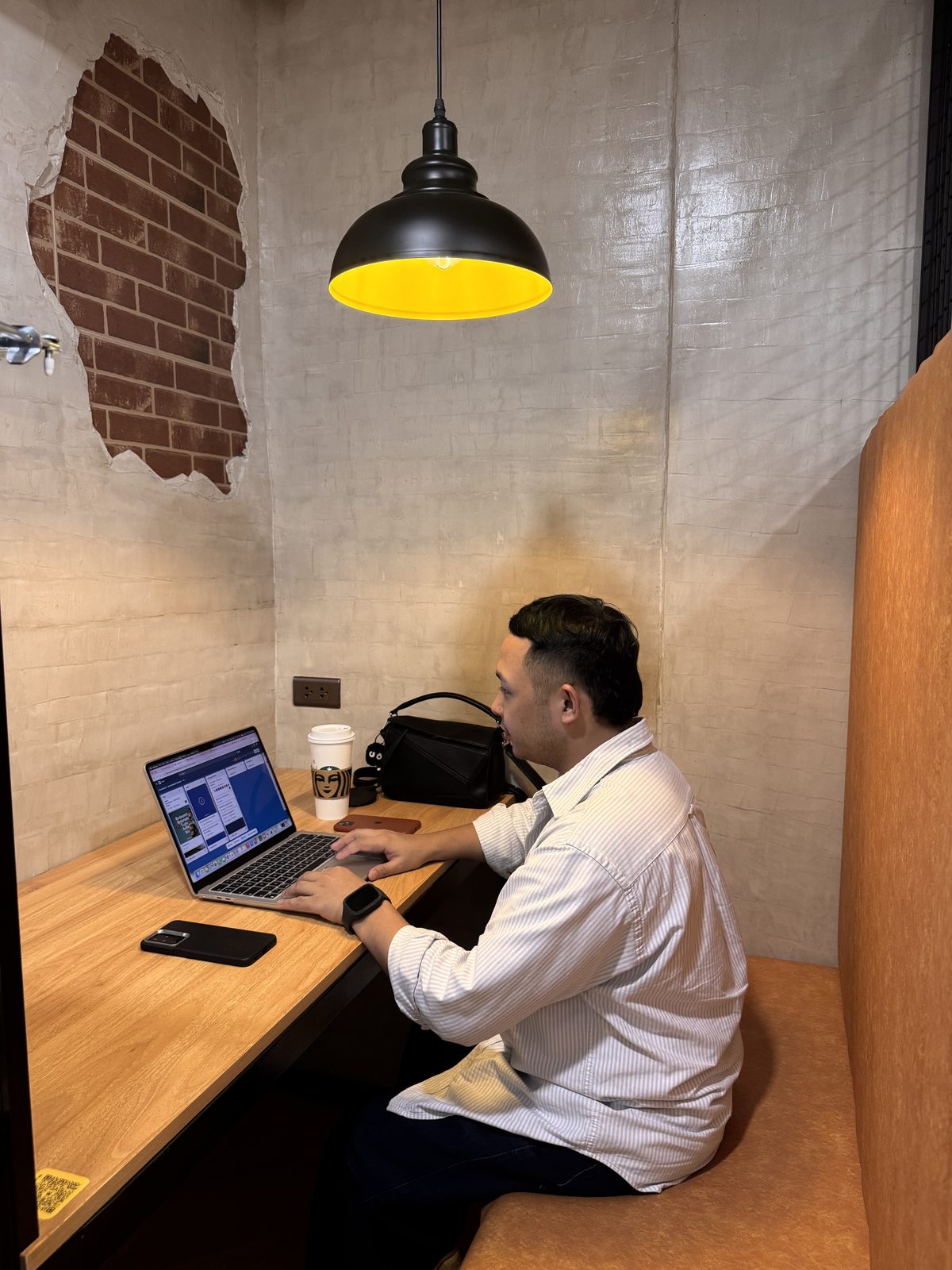 Person working on a laptop in a private cubicle at Kataid
